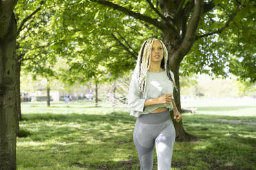 Frau in Sportkleidung beim Joggen im Park - AMWF01062