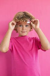 Boy wearing pink t-shirt against colored background - MEGF00163