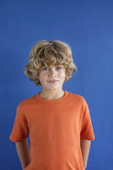 Junge mit blondem Haar vor blauem Hintergrund - MEGF00171
