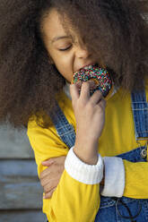 Afro girl biting fresh doughnut - MEGF00214