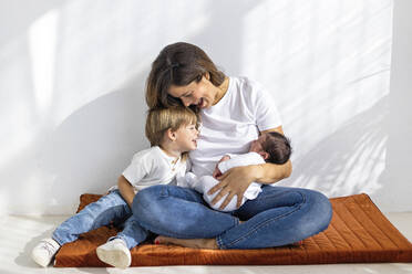 Mutter verbringt ihre Freizeit mit Sohn und Tochter, die zu Hause vor der Wand sitzen - MEGF00244