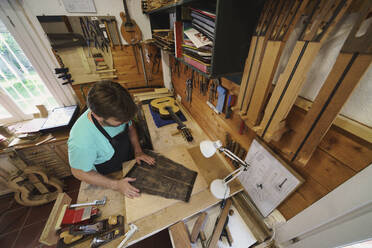 Guitar maker working in workshop - JSMF02545