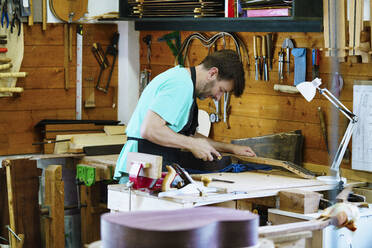 Handwerker an der Werkbank in der Werkstatt - JSMF02549