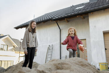 Happy mother playing with daughter outside house - VIVF00247