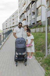 Familie mit Kinderwagen auf dem Fußweg - VIVF00316