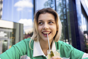 Happy woman having drink with stainless steel straw - WPEF06711