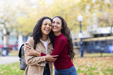 Happy women standing together in park - WPEF06722