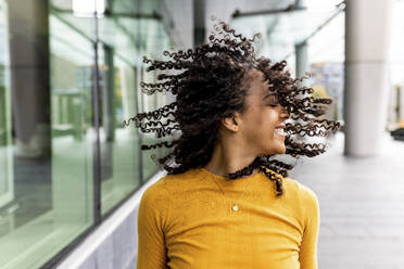 Unbekümmerte Frau, die sich auf dem Gehweg die Haare wirft - WPEF06780