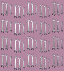 Pattern of rows of wrenches flat laid against pink background - GIOF15680