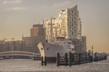 Deutschland, Hamburg, Cap San Diego Schiff im Hafen in der Abenddämmerung mit Elbphilharmonie im Hintergrund - KEBF02494