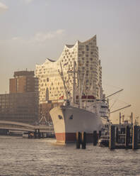 Deutschland, Hamburg, Cap San Diego Schiff im Hafen in der Abenddämmerung mit Elbphilharmonie im Hintergrund - KEBF02495