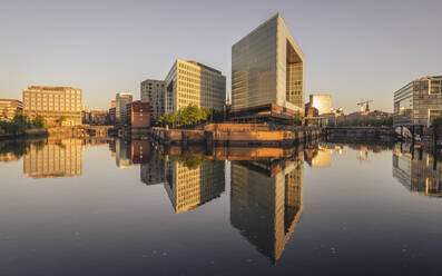 Deutschland, Hamburg, Bürogebäude spiegeln sich in der Elbe in der Abenddämmerung - KEBF02498
