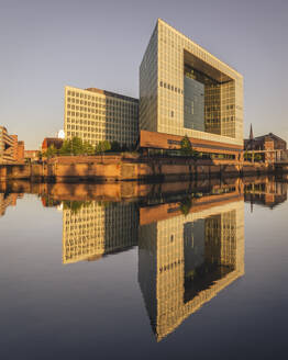Deutschland, Hamburg, Bürogebäude spiegeln sich in der Elbe in der Abenddämmerung - KEBF02499