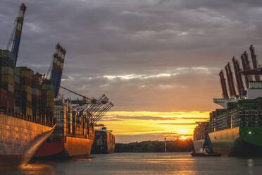 Germany, Hamburg, Container ships in Port of Hamburg at sunset - KEBF02516