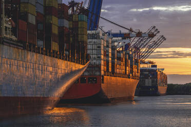 Deutschland, Hamburg, Containerschiffe im Hamburger Hafen in der Abenddämmerung - KEBF02517