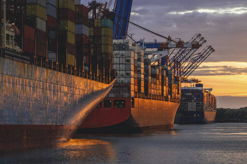 Germany, Hamburg, Container ships in Port of Hamburg at dusk - KEBF02517