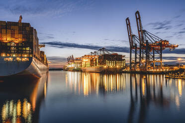 Deutschland, Hamburg, Containerschiffe im Hamburger Hafen in der Abenddämmerung - KEBF02519