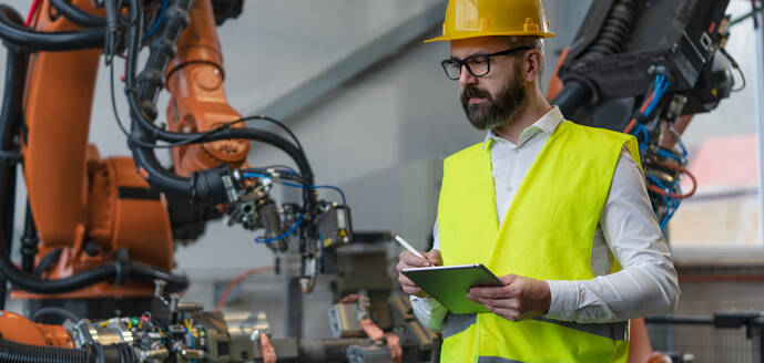 Ein Automatisierungsingenieur hält einen Scanner in einer Fabrik in der Hand. - HPIF00718