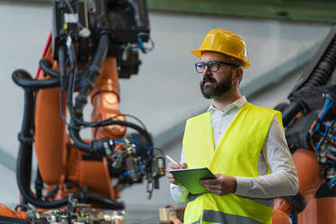 An automation engineer holding scanner in industrial in factory. - HPIF00719