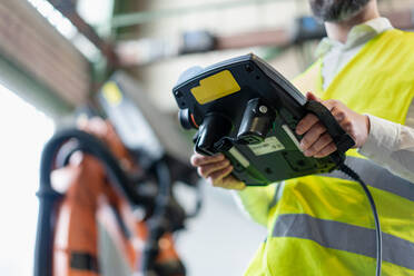 A close-up of automation engineer holding scanner in industrial in factory. - HPIF00724