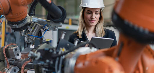 Ein Porträt eines weiblichen Chefingenieurs in einer modernen Industriefabrik, der ein Tablet benutzt. - HPIF00727