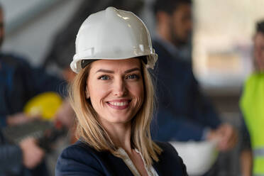 Ein Porträt eines weiblichen Chefingenieurs in einer modernen Industriefabrik, der in die Kamera schaut. - HPIF00735
