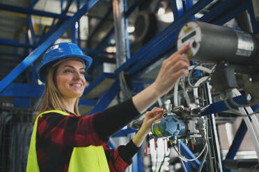 A woman worker woring in industrial factory, programming machine. - HPIF00753