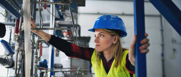 A portrait of female engineer working in industrial factory - HPIF00754