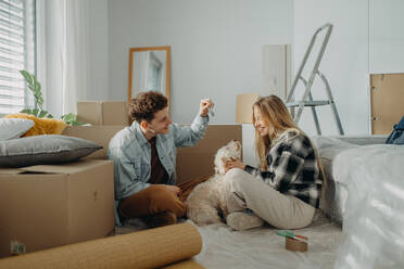 Ein fröhliches junges Paar in seiner neuen Wohnung, das den Umzug plant. - HPIF00786