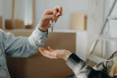Ein glückliches junges Paar, das sein neues Haus kauft und die Schlüssel vom Immobilienmakler erhält - HPIF00789
