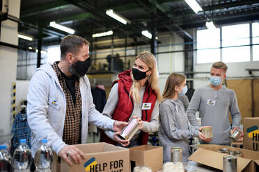 Freiwillige Helfer sortieren gespendete Lebensmittel für den Bedarf der ukrainischen Migranten, Konzept der humanitären Hilfe. - HPIF00846