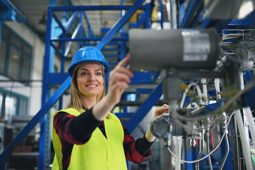 A portrait of female engineer working in industrial factory - HPIF00892