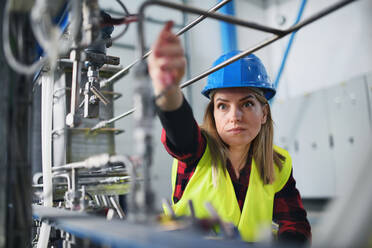 A portrait of female engineer working in industrial factory - HPIF00894