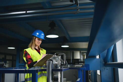 Porträt einer Ingenieurin bei der Arbeit in einer Industriefabrik - HPIF00900