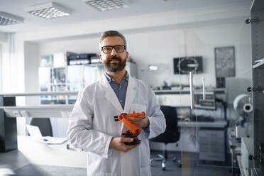 Robotics engineer man holding modern robotic arm in laboratory office. - HPIF00934