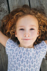 Girl lying on wooden floor - ADSF40421