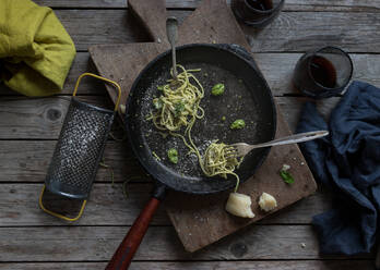 Leckere Spaghetti mit Pestosauce, Spinat und Parmesankäse. Reibe und ein paar Rotweingläser sind im Bild zu sehen - ADSF40851