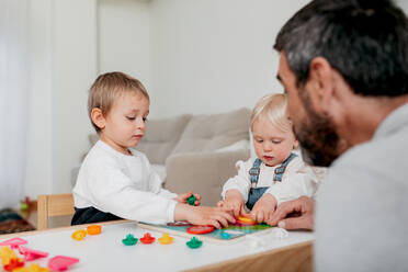 Crop bärtigen Vater die Zeit mit entzückenden Kinder spielen Brettspiel im Haus Zimmer - ADSF40934