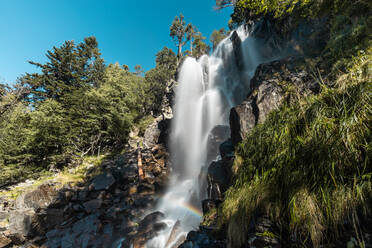 Niedriger Winkel eines schnell fließenden Wasserfalls in felsigem Gelände im Wald in den Pyrenäen in Lleida - ADSF40980