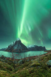 Herrlicher Blick auf die bunten Nordlichter, die den Nachthimmel über den felsigen Bergen in der Nähe des Sees im Winter auf den Lofoten erleuchten - ADSF41006