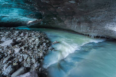 Das Innere einer atemberaubenden Eishöhle mit nassem Boden im Inneren des Vatnajokull-Gletschers an einem Wintertag in Island - ADSF41059