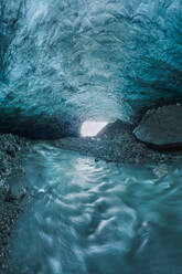 Das Innere einer atemberaubenden Eishöhle mit nassem Boden im Inneren des Vatnajokull-Gletschers an einem Wintertag in Island - ADSF41061