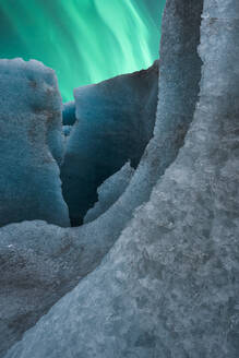 Unebene Eisformationen des Vatnajokull-Gletschers im Kontrast zu den leuchtenden grünen Polarlichtern an einem Wintertag in Island - ADSF41326