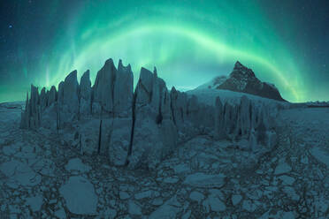 Erstaunliche Kulisse des Fjallsarlon-Gletschers in der vulkanischen Landschaft des Vatnajokull-Nationalparks in Island im Winter vor grün leuchtenden Polarlichtern - ADSF41327
