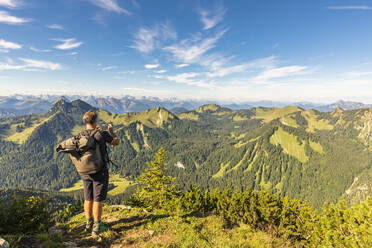 Deutschland, Bayern, Männlicher Wanderer bewundert die umliegende Landschaft vom Gipfel des Hirschbergs - FOF13218