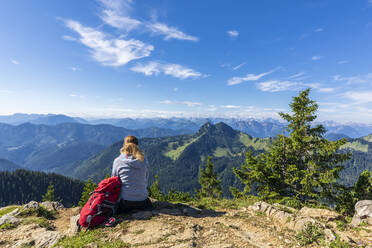 Deutschland, Bayern, Wanderin bewundert Aussicht auf Rossstein und Buchstein in den Bayerischen Voralpen - FOF13219