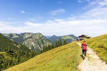 Deutschland, Bayern, Wanderin auf dem Weg zu Berghütten in den Bayerischen Voralpen - FOF13223