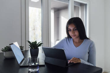 Young woman studying through laptop at home - MEUF08608