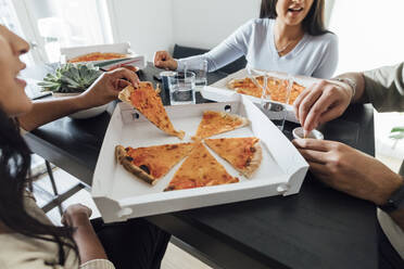 Hands of women and man by pizza box on table at home - MEUF08629