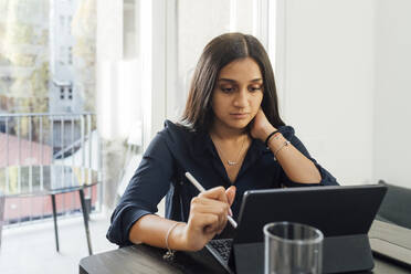 Frau studiert mit Tablet-PC auf dem Tisch zu Hause - MEUF08650